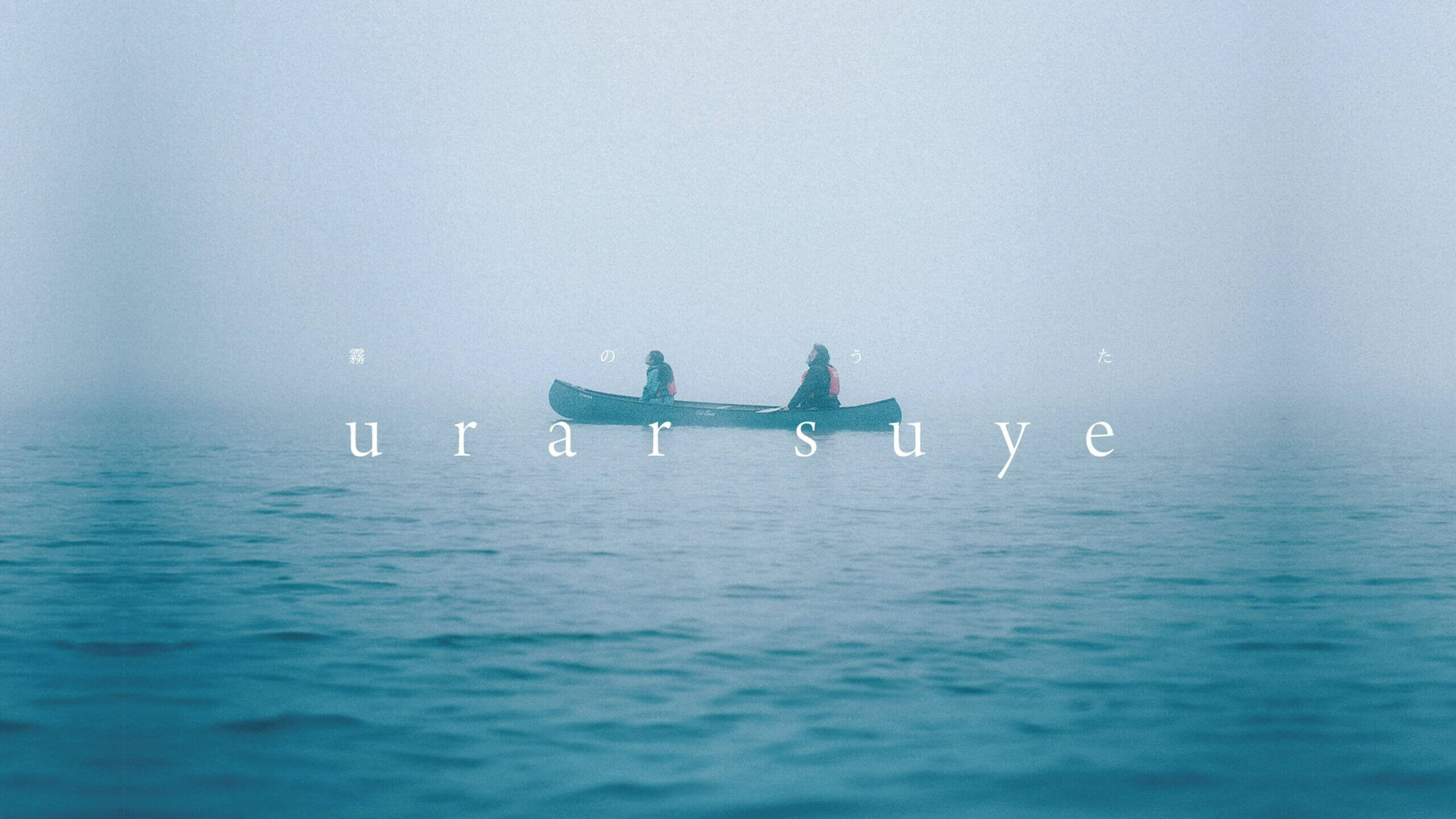 短編映画『urar suye』のメインビジュアル。霧に包まれた湖上で二人がカヌーに乗り、阿寒の自然を映し出す
