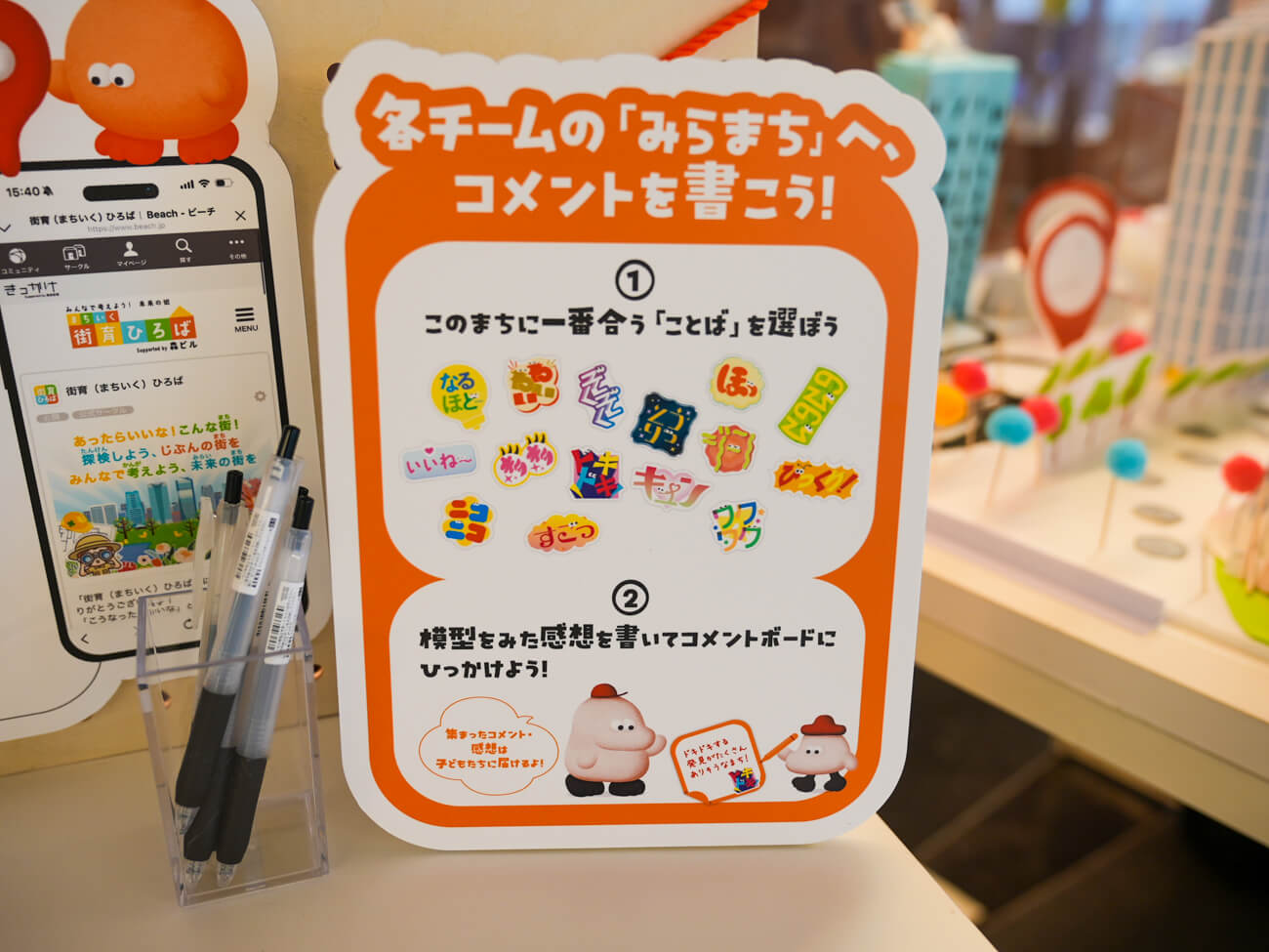 ヒルズで行われた展示に置いてあった、パネルの写真。パネルには「各チームのみらまちへ、コメントを書こう!」との文字があり、すぐ下には子どもたちの持っていたシールがたくさん貼られている