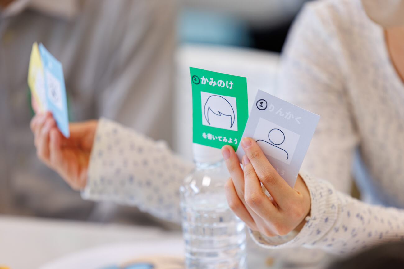 ワークショップで使用されたツールを見せる子どもの手元