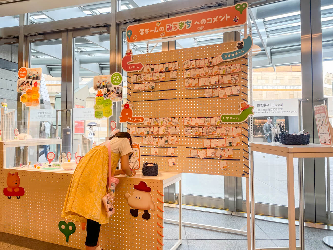 ヒルズで行われた展示風景の写真。壁際にコメントボードが設置され、そこには子どもたちによる手書きのコメントがびっしりと貼り付けられている