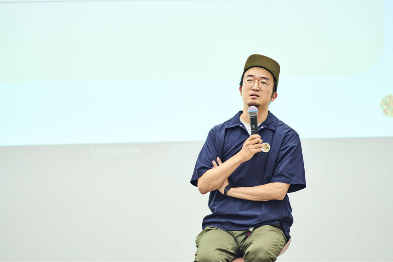 登壇者の浅野さんがマイクを持って壇上で話している様子