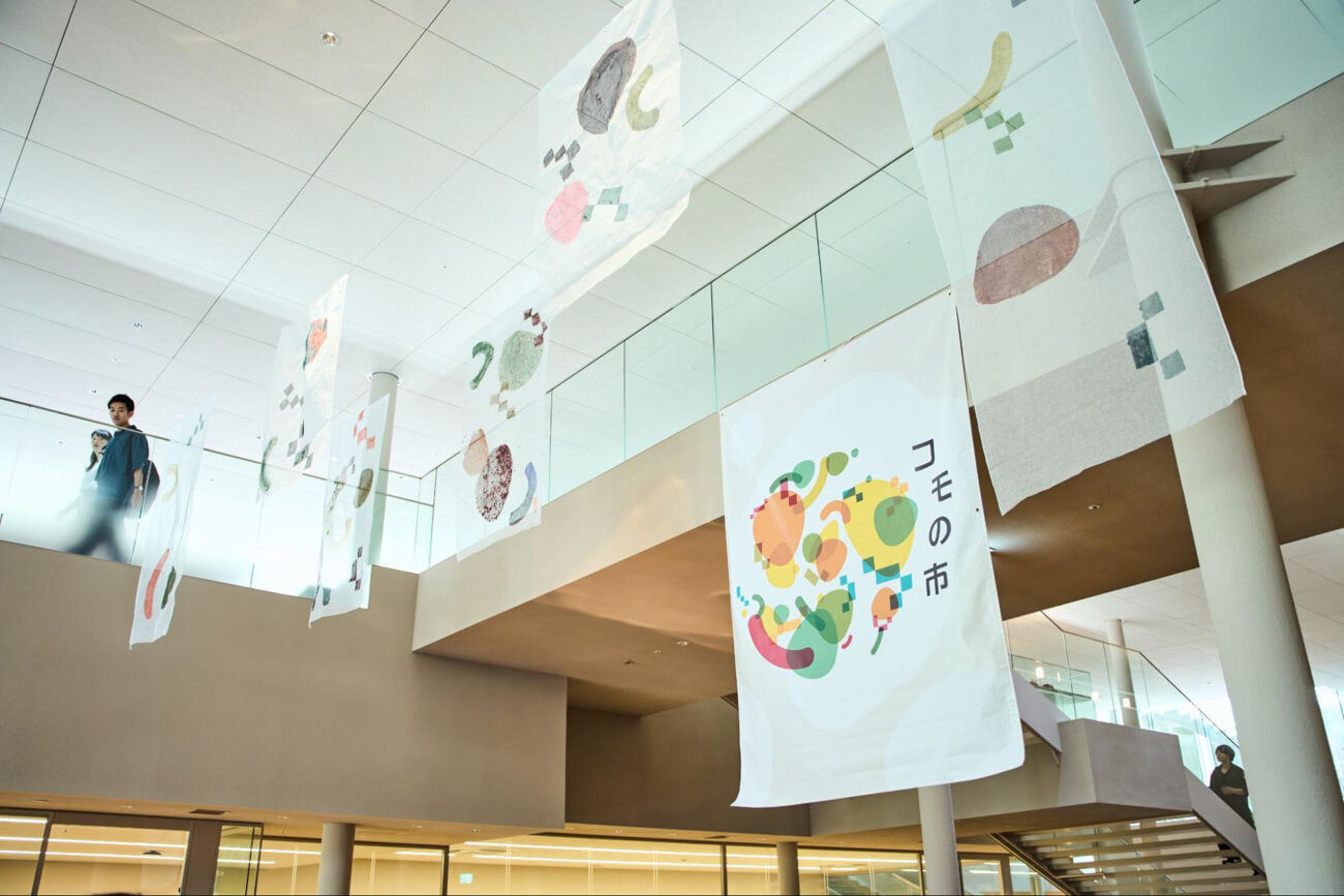 色とりどりのイラストがあしらわれた幕が、1階から2階にかけての吹き抜けの位置に吊らされている様子