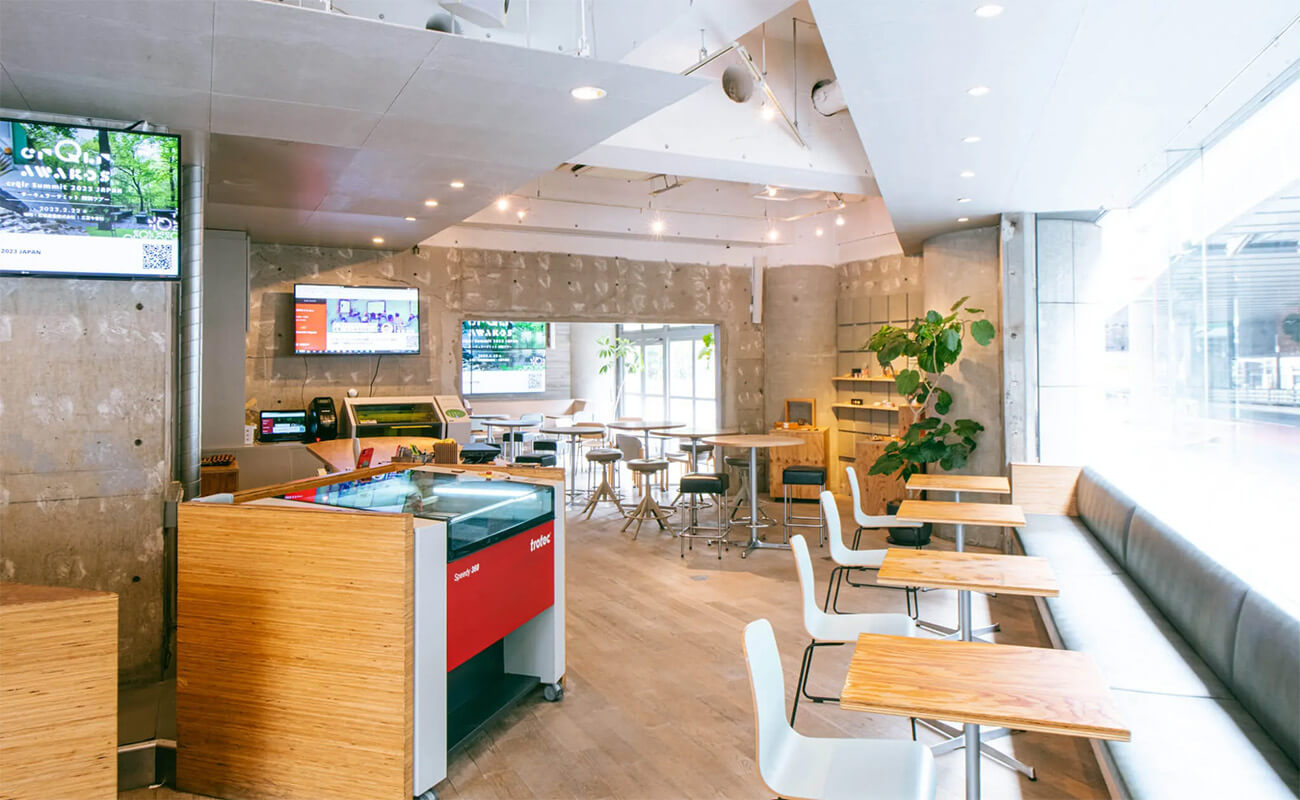 FabCafe Tokyoの店内。レーザーカッターなどの機材とカフェ席が並び、創造活動と交流の場として設計されている