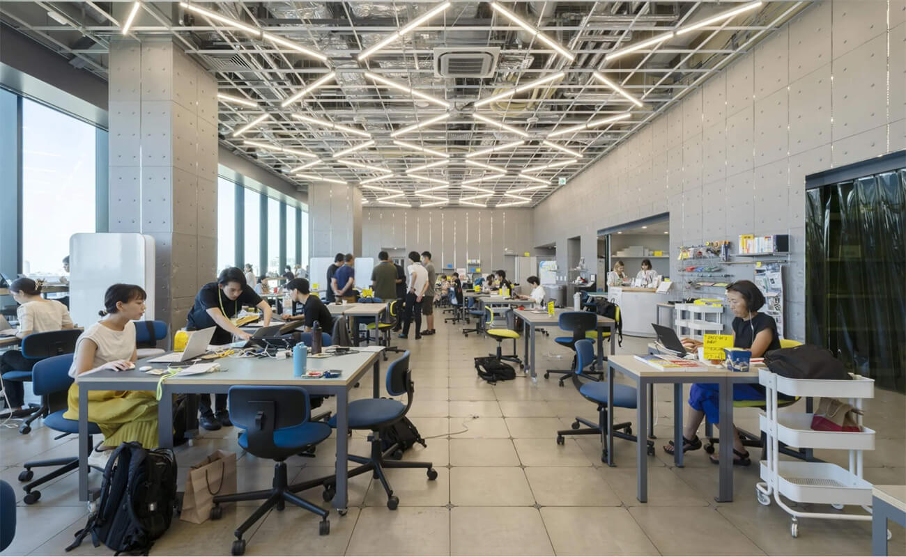 SHIBUYA QWSの共創スペース。広いフロアで多様な人々が作業や対話を行い、交流の拠点として活用されている