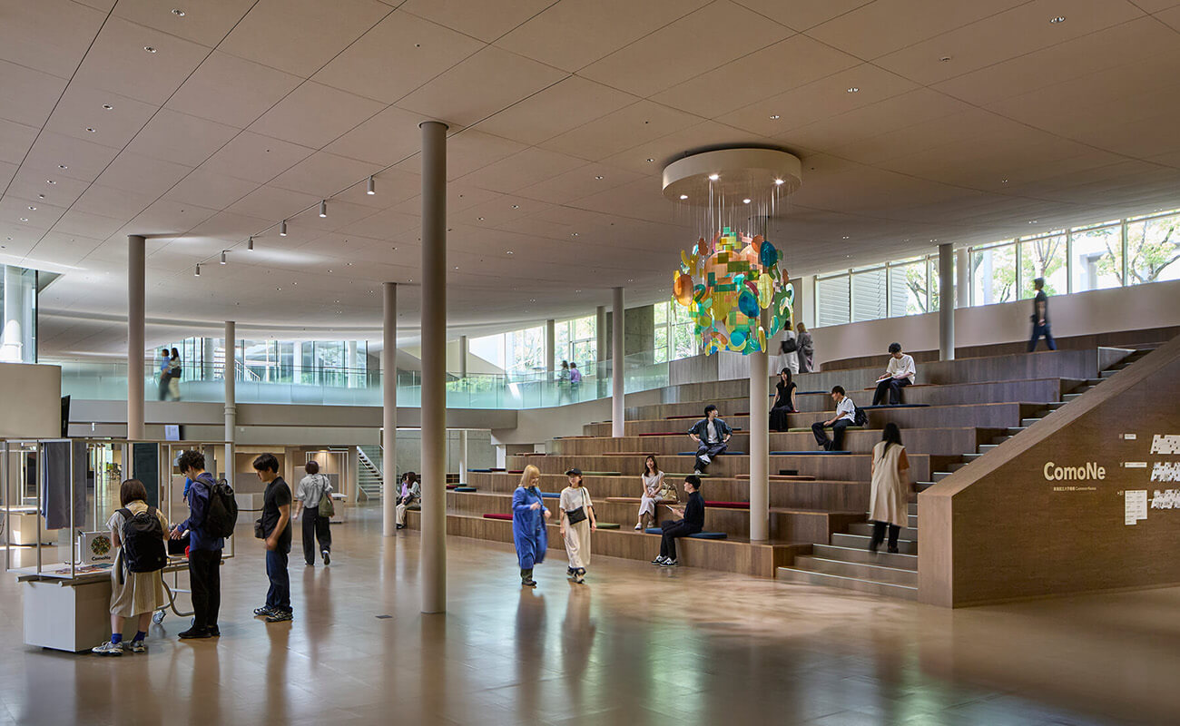 名古屋大学構内の共創拠点ComoNe。広い吹き抜け空間に階段状の座席があり、学生や来訪者が集い交流している