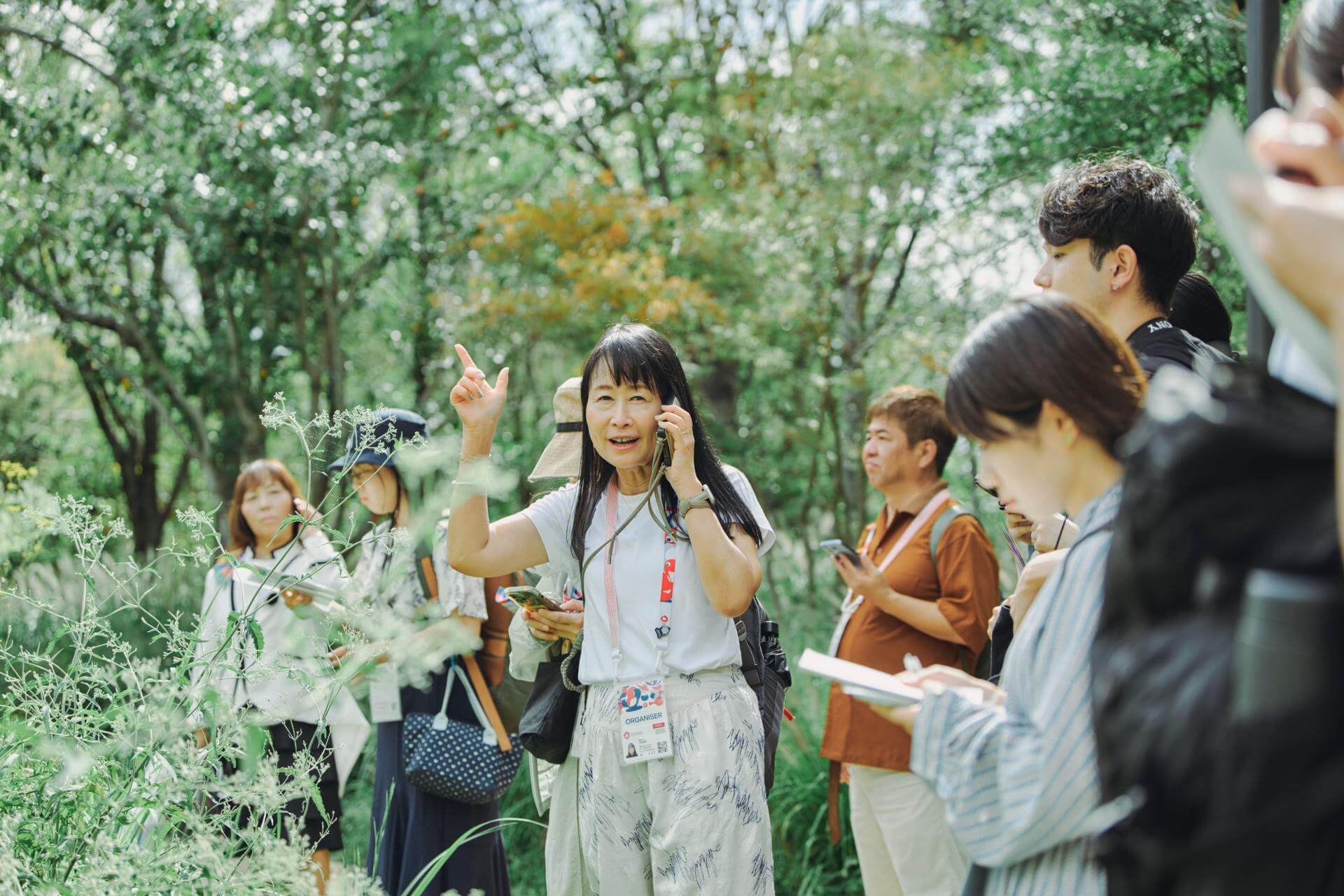 写真：静けさの森のアート作品を説明するアートコーディネーターの寺浦薫さん