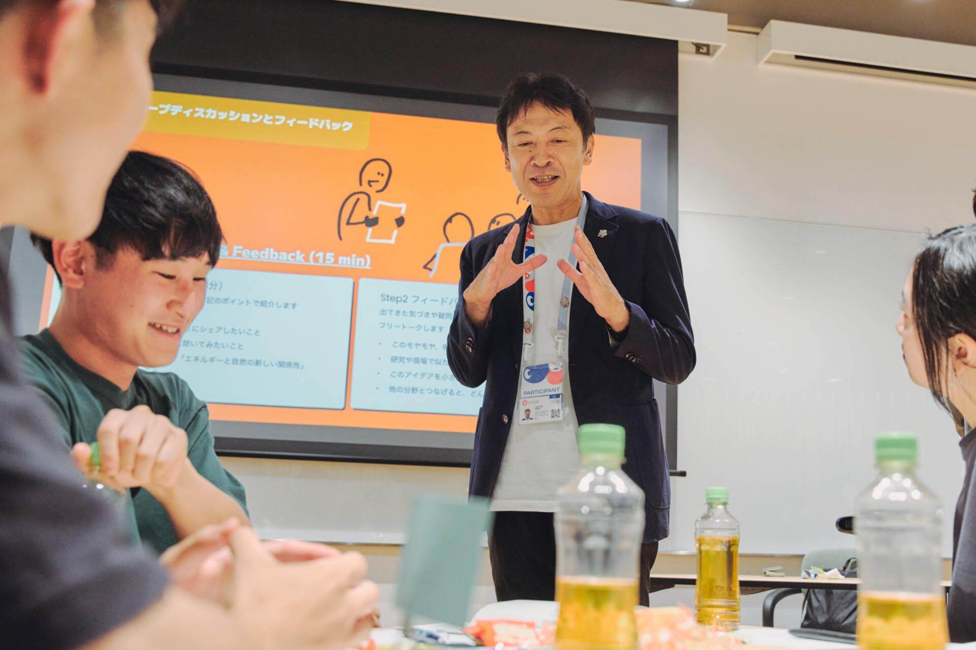 写真：学生たちの議論に混ざる、電気事業連合会 大阪・関西万博推進室 室長／電力館 可能性のタマゴたち 館長の岡田康伸氏