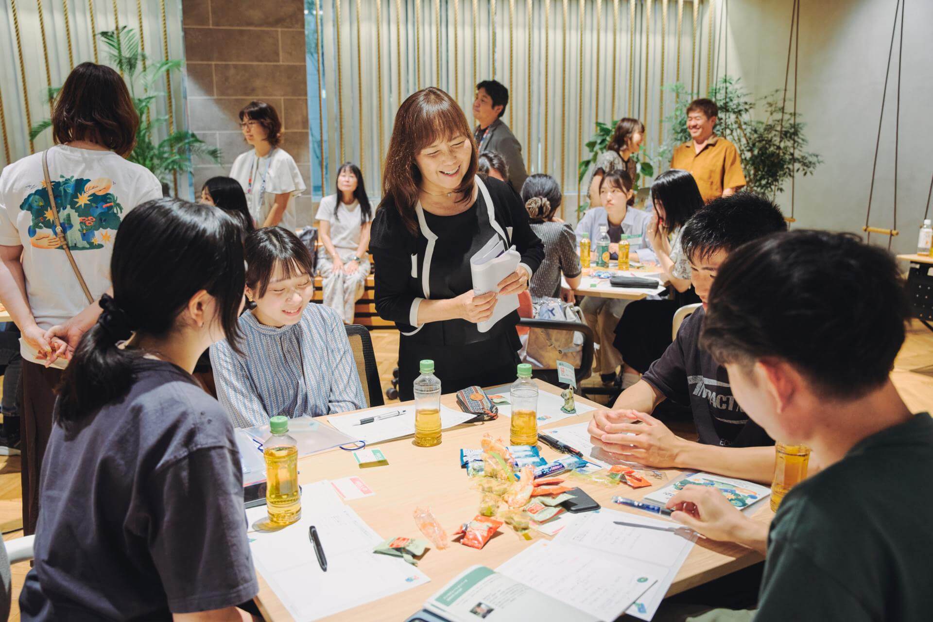 写真：学生たちの議論に混ざる大阪ガス株式会社 広報部 大阪・関西万博プロジェクト室 室長／日本ガス協会ガスパビリオン 館長の金澤 成子氏