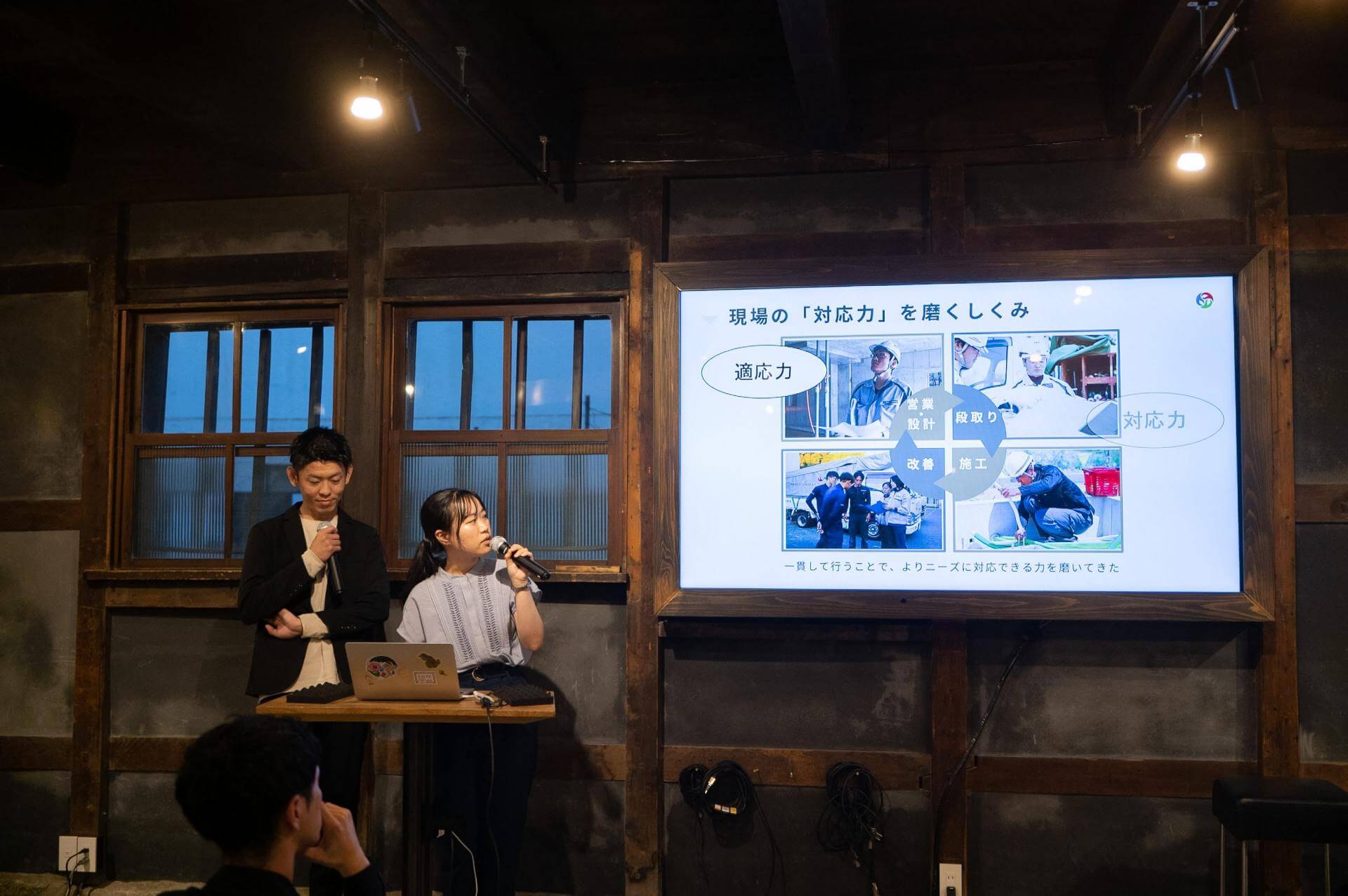 写真：2名がスライドを使いながらプレゼンテーションをする