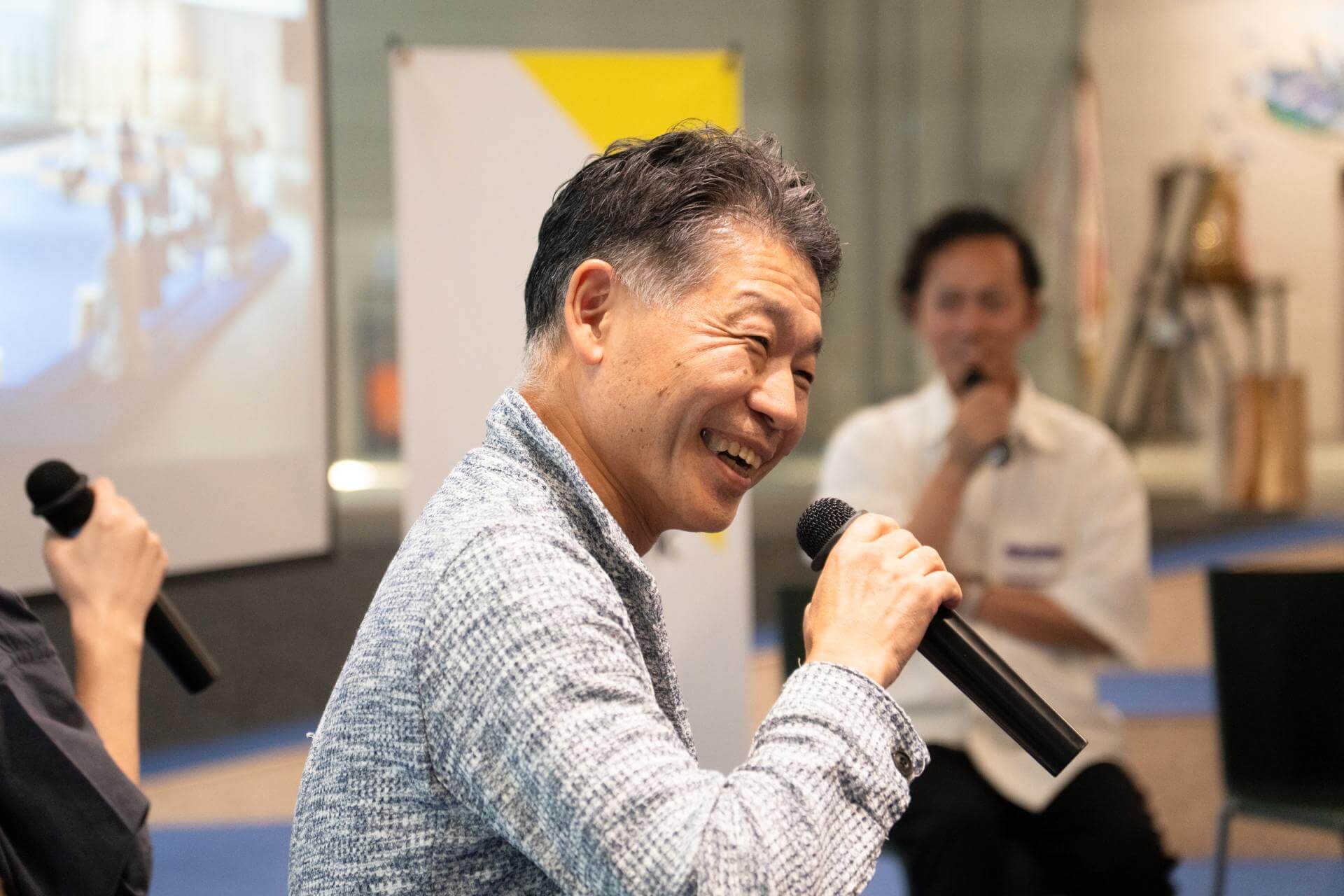 写真:マイクを手に、話す男性