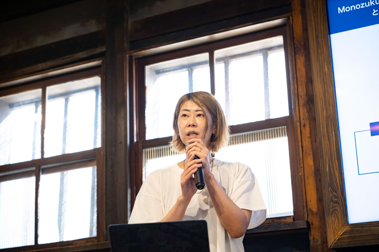 女性がマイクを持ち、登壇者として話している様子