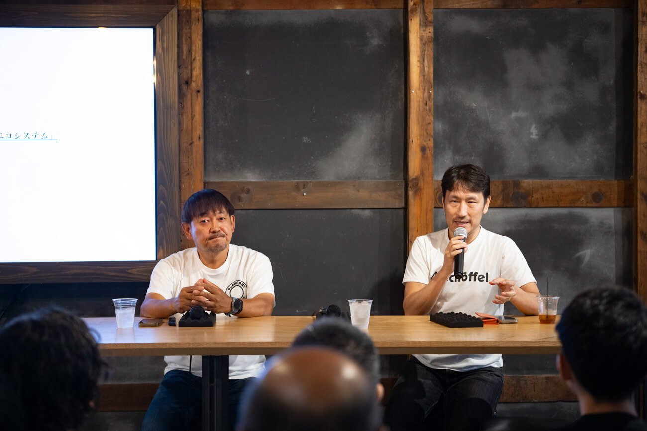 二人の男性が長机につき、登壇者として話している様子