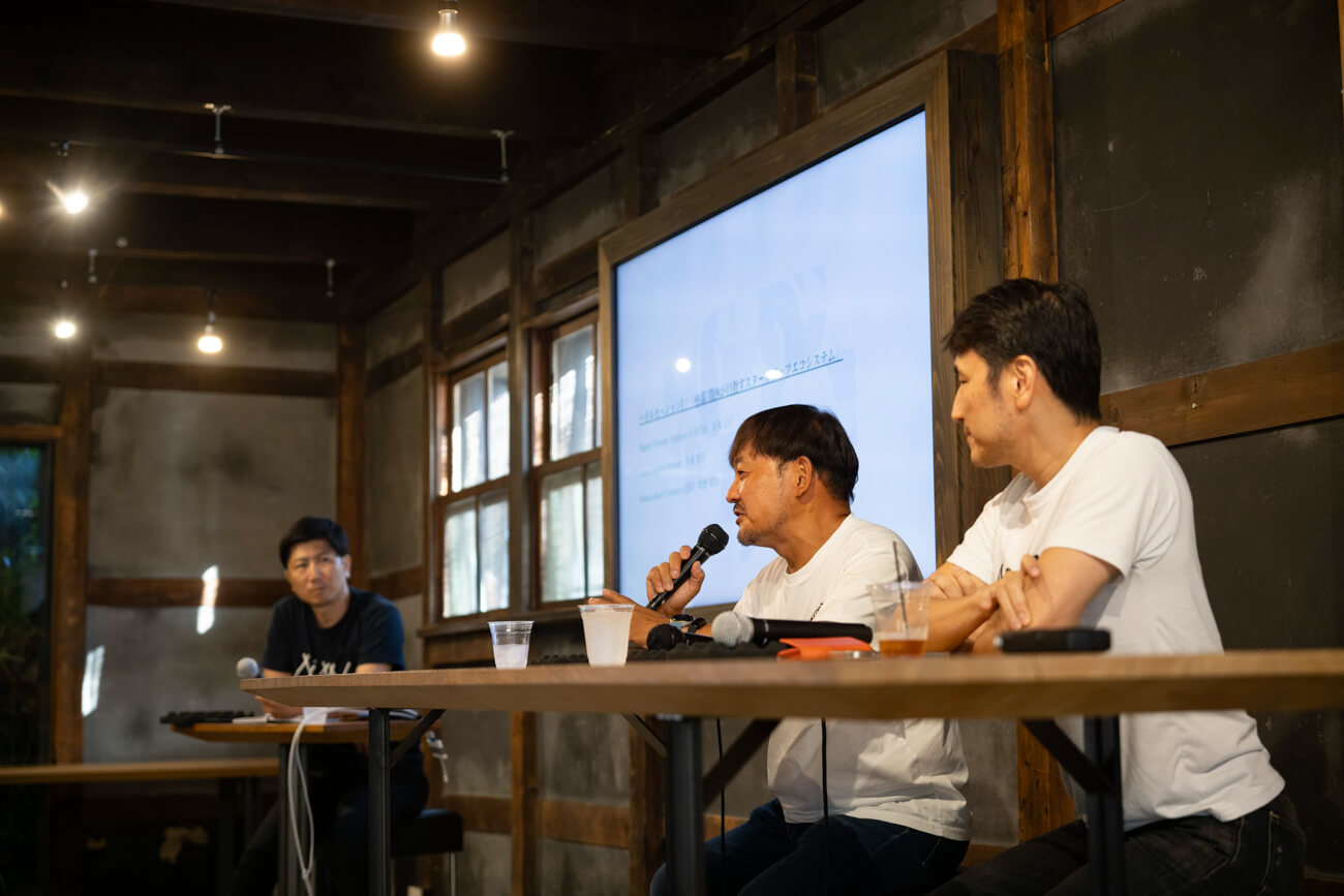 ３人の男性が長机につき、登壇者として話している様子