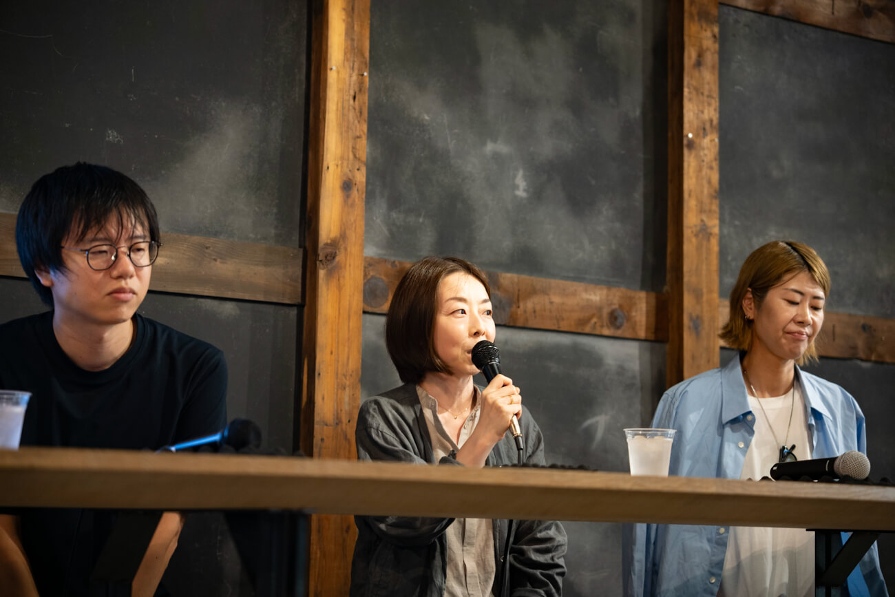 女性がマイクを持ち、観客に向けて話している様子