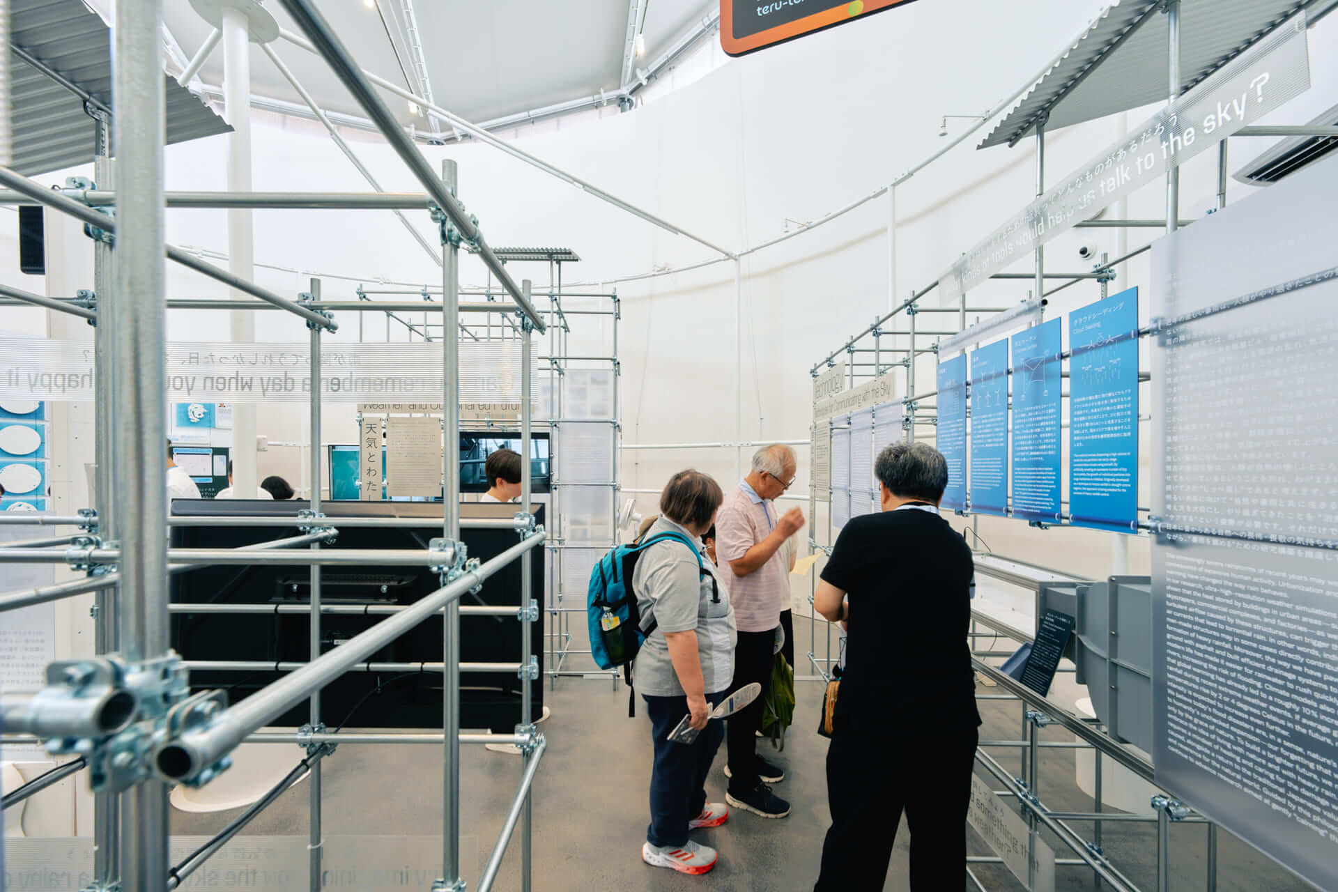 豪雨制御プロジェクトの技術展示を閲覧している来客者の様子