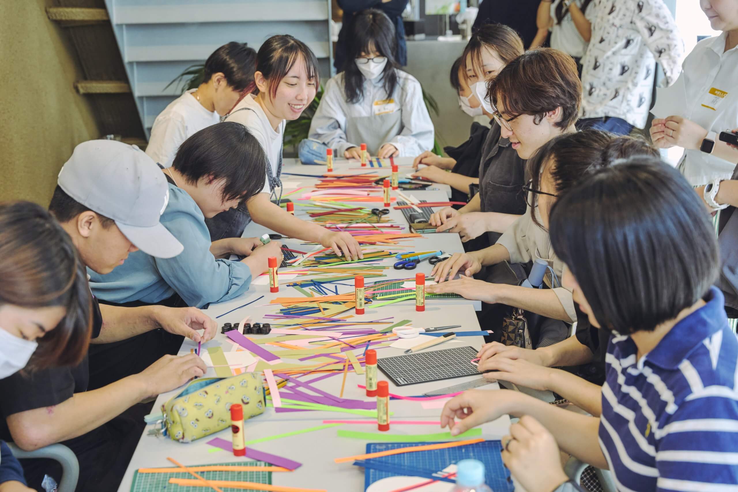 写真：生徒が色紙を組み合わせ、パーツを作る様子