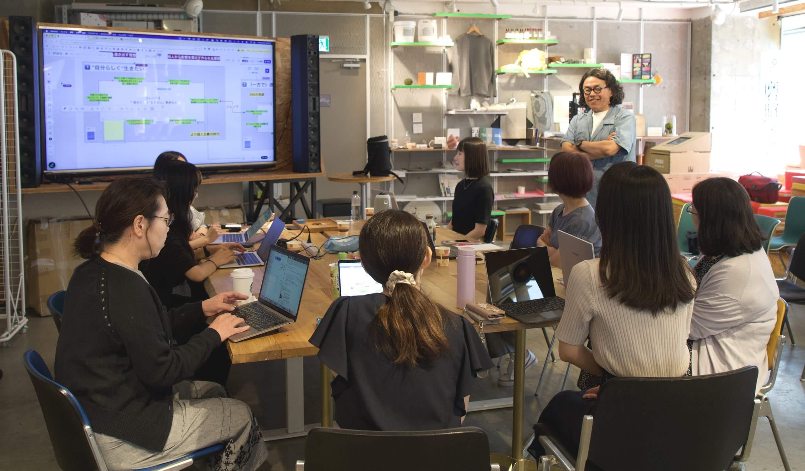 AIが生成したループ図を見ながらディスカッションする月次定例の風景。オフラインとオンラインのハイブリッドで行われた会議の音声はすべて録音〜文字起こしされ、すべてのアイデアや意見がAIの分析のソースとなる。