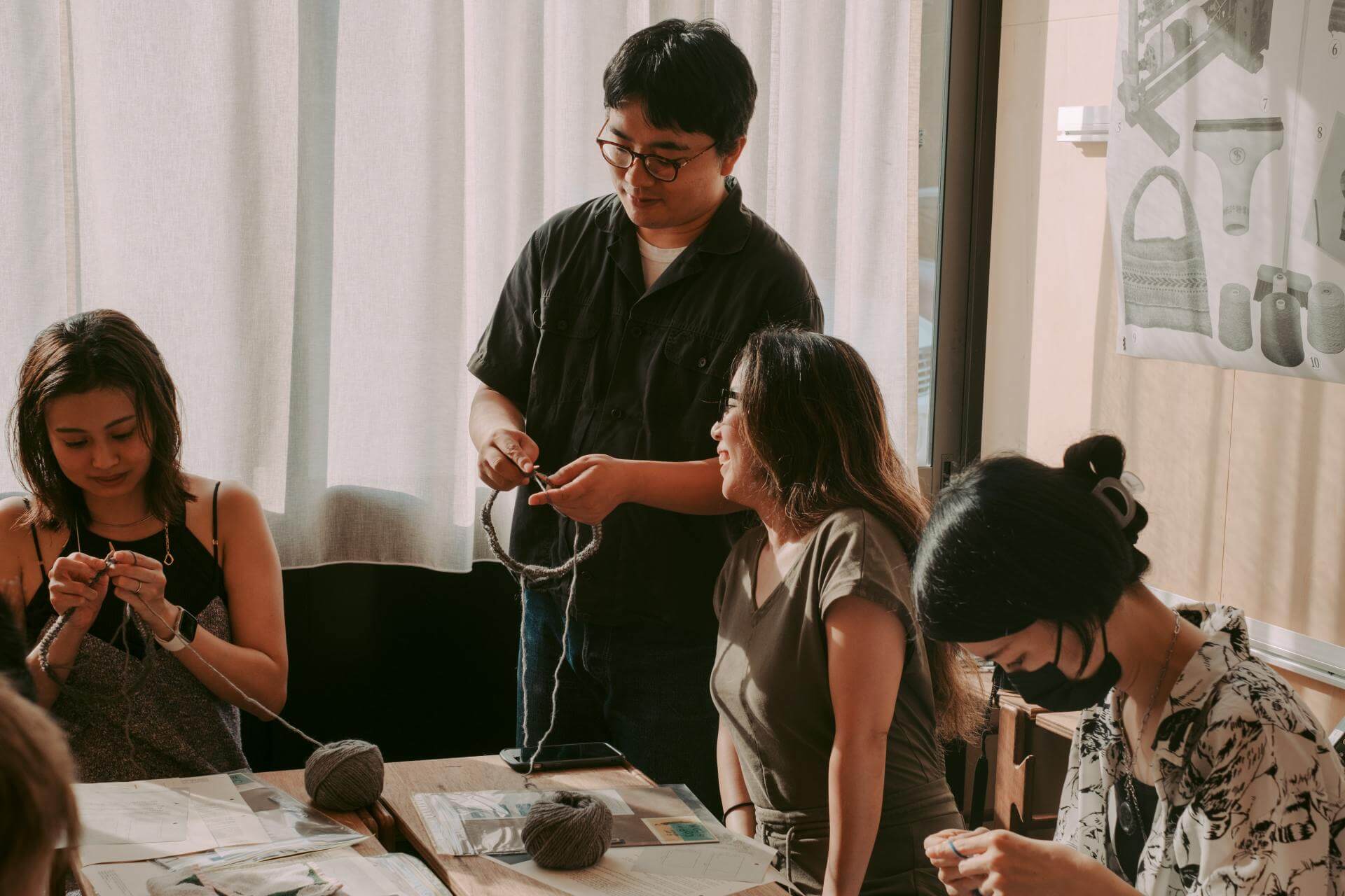 写真：編み物を習う受講者たち