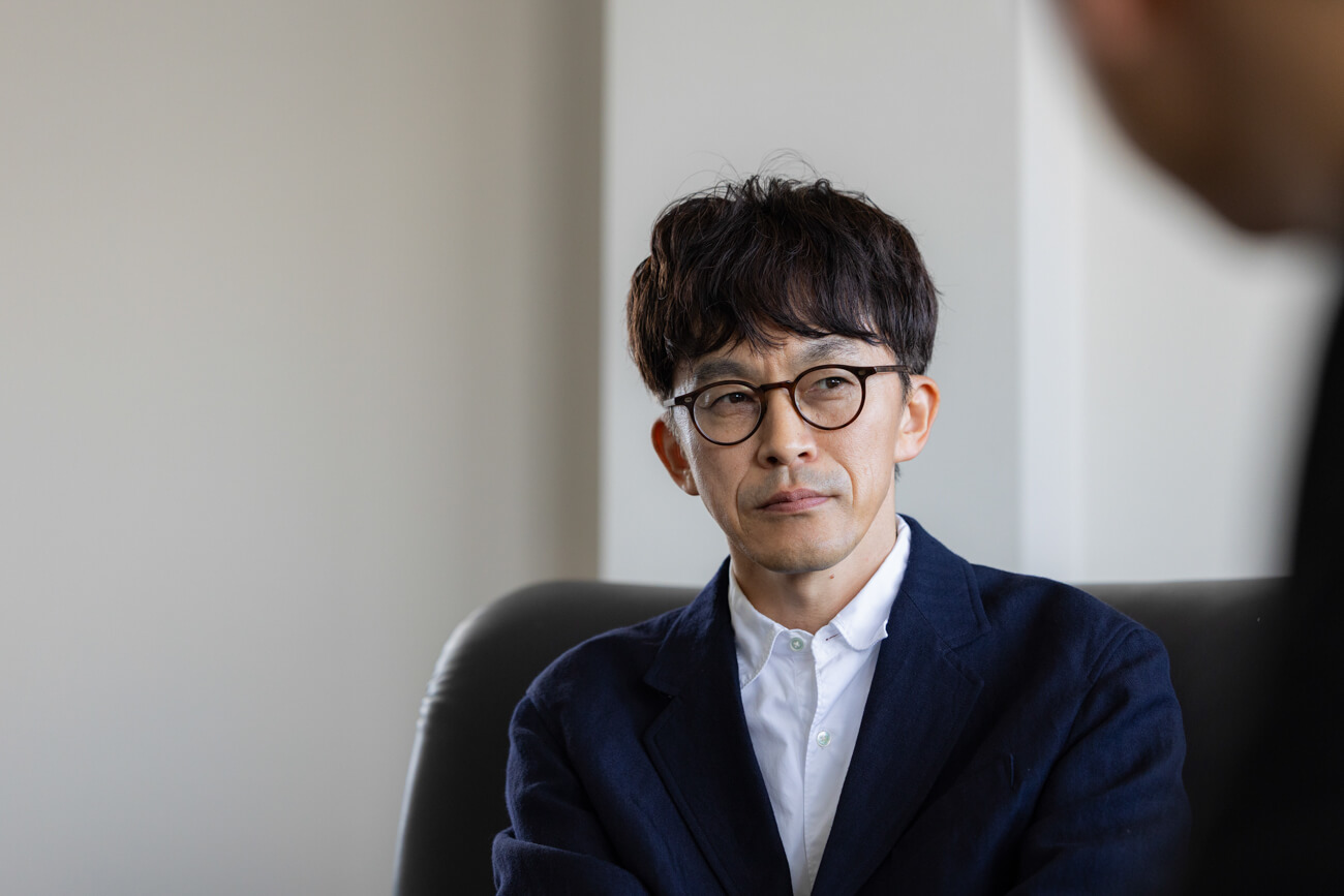 男性の写真。真剣な表情で人の話を聞いている