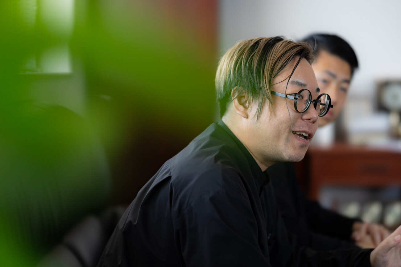 応接室のソファに座る男性が話している横顔の写真