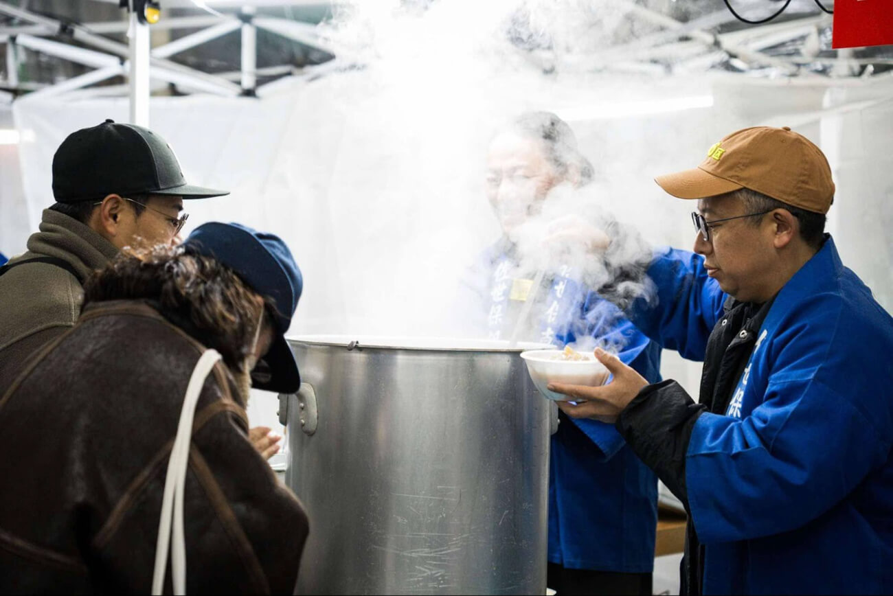朝市の写真。大きな寸胴鍋から美味しそうな湯気が上がっている
