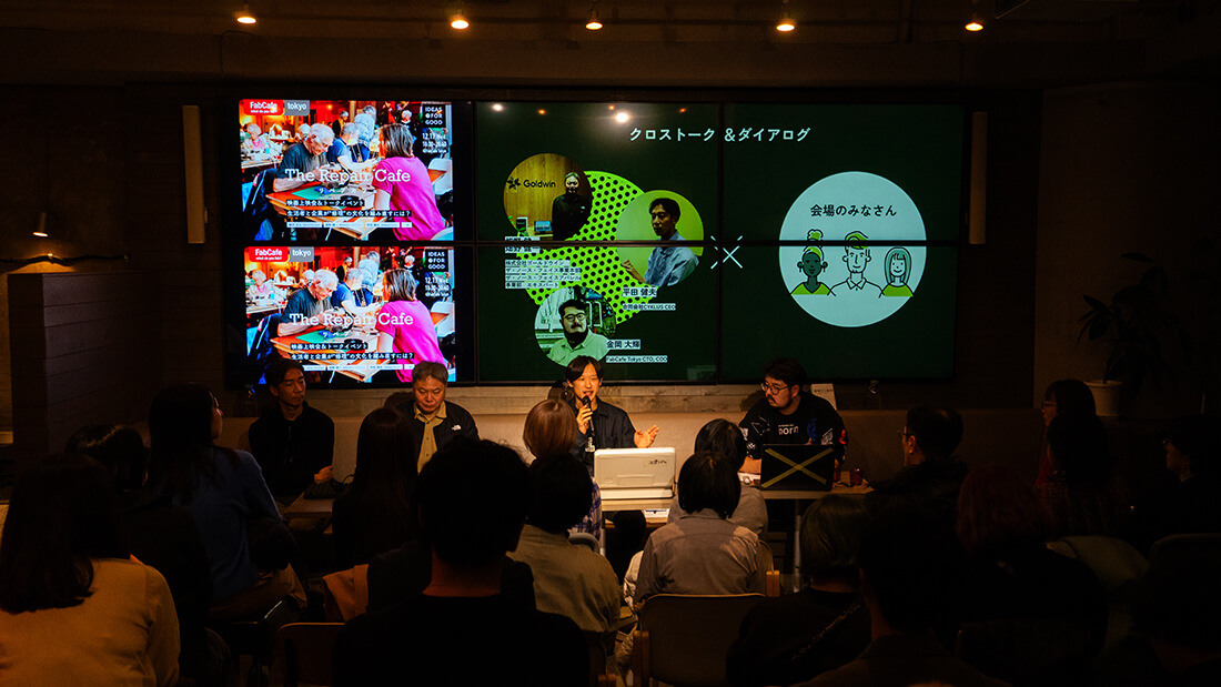 登壇者が横並びになっている。後ろに大型ディスプレイがあり、登壇者のプロフィールが表示されている。