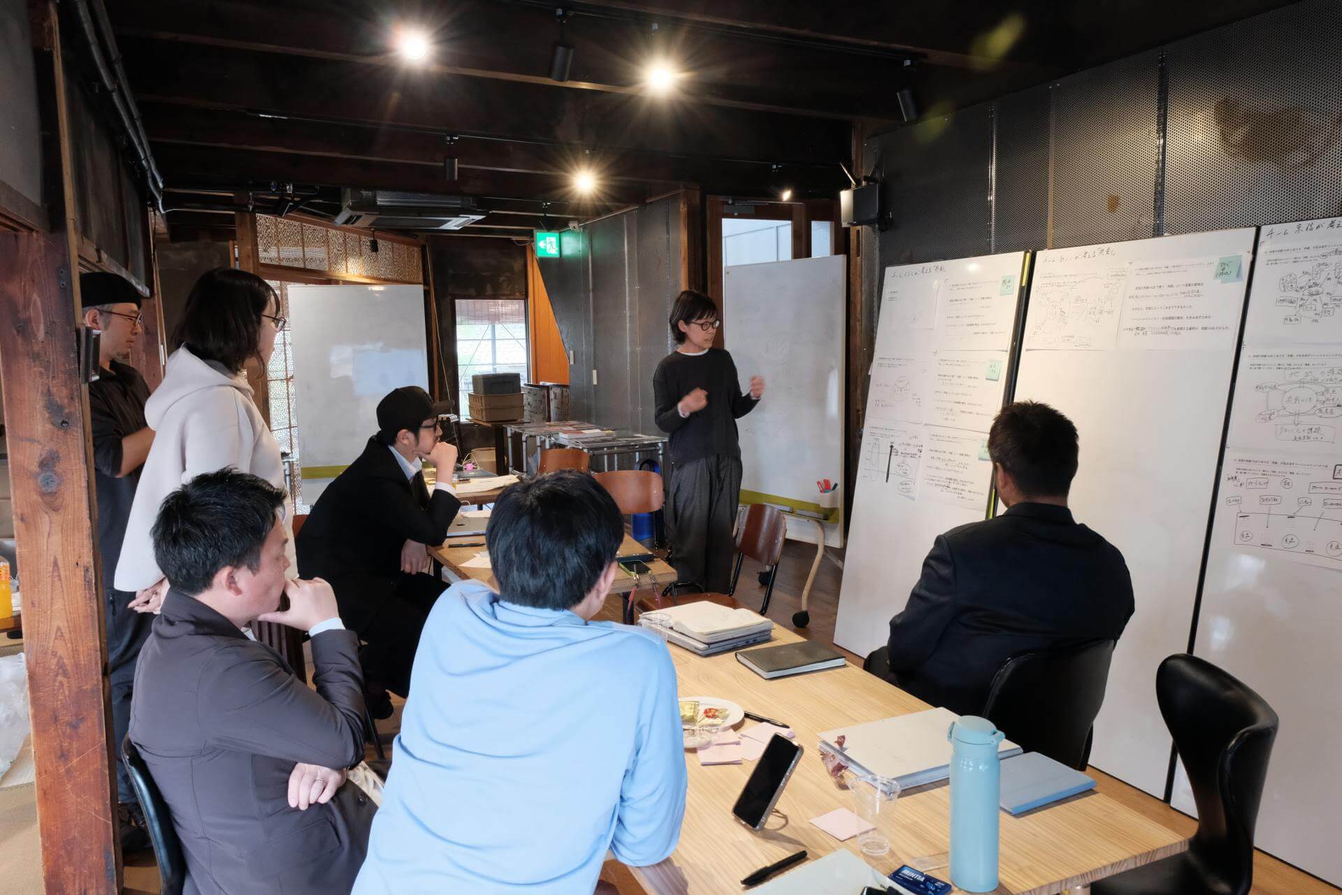 写真：ホワイトボードを囲むプロジェクトメンバー