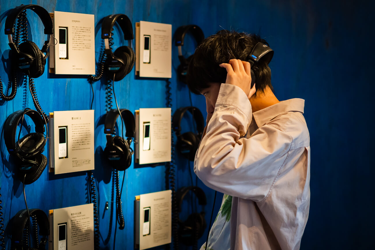 展示会場の様子。壁にかけられているのは、木の板に埋め込まれたいくつもの音楽プレーヤーと、そこにつながるヘッドフォン