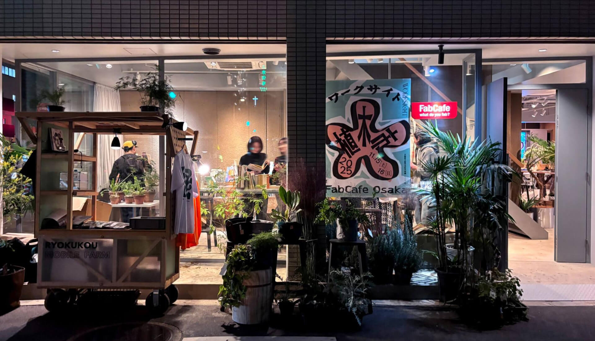 植物をテーマにしたマーケットイベント「WORKSIGHT植木市」開催時のFabCafe Osaka夜の外観。軒先まで緑が広がり、通常営業時とは異なる表情に。