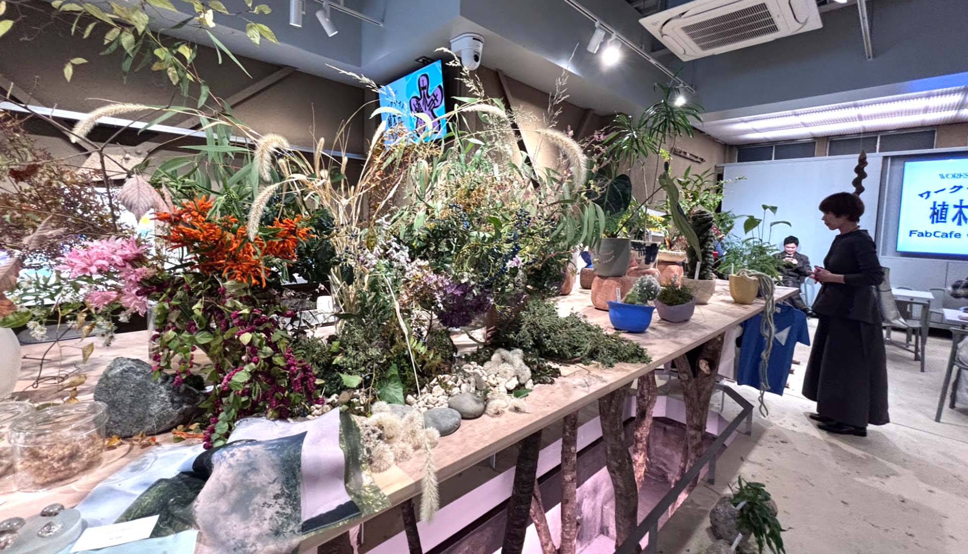 「WORKSIGHT植木市」開催時の店内。センターテーブルいっぱいに植物や花器が並び、FabCafe Osakaが一夜限りのマーケット空間に。