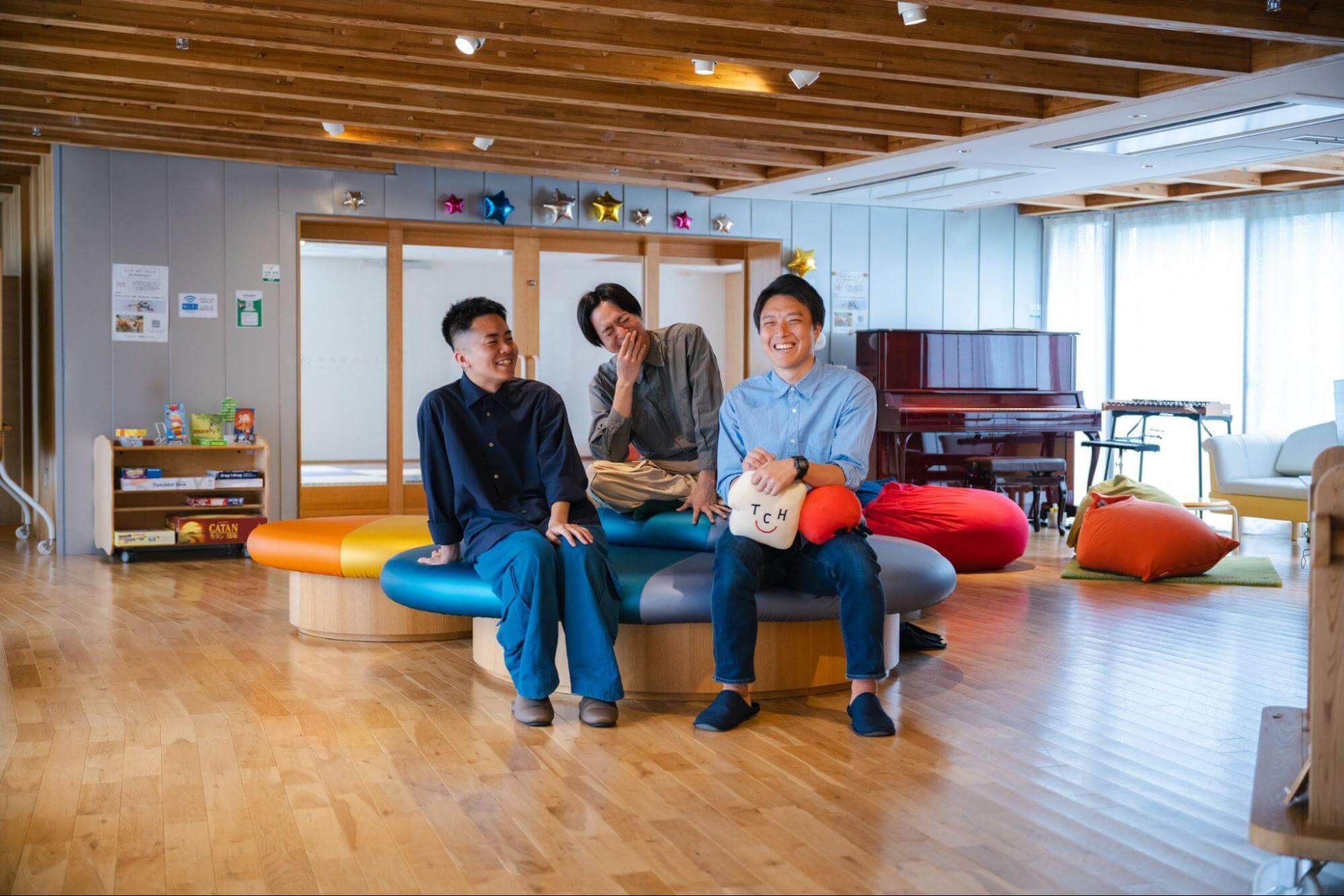 写真：男性3名が笑顔で話す様子