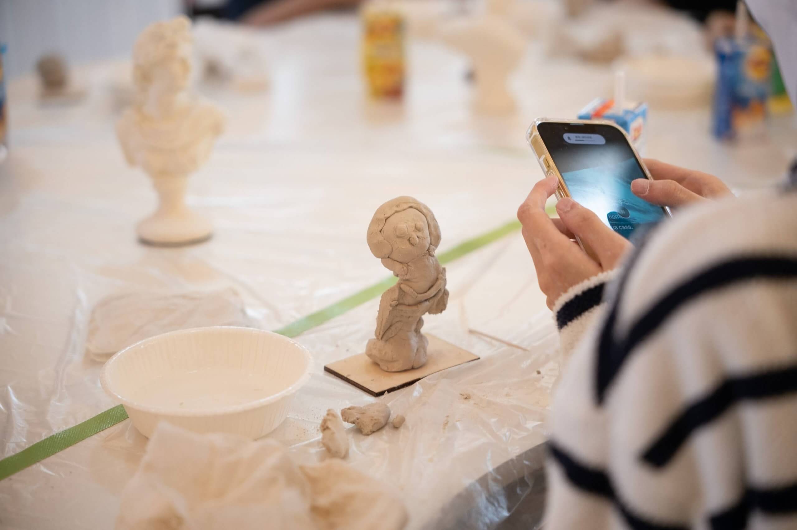 写真：粘土作品をスマホで撮影する子ども