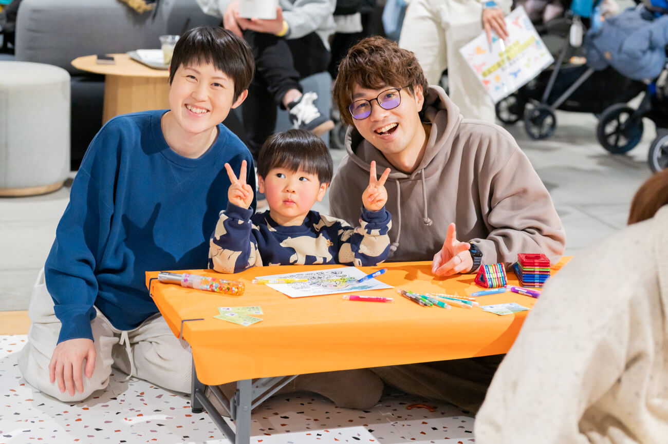 来場してくれたご家族の様子。両親にはさまれた小さな子どもが、ピースサインをしている