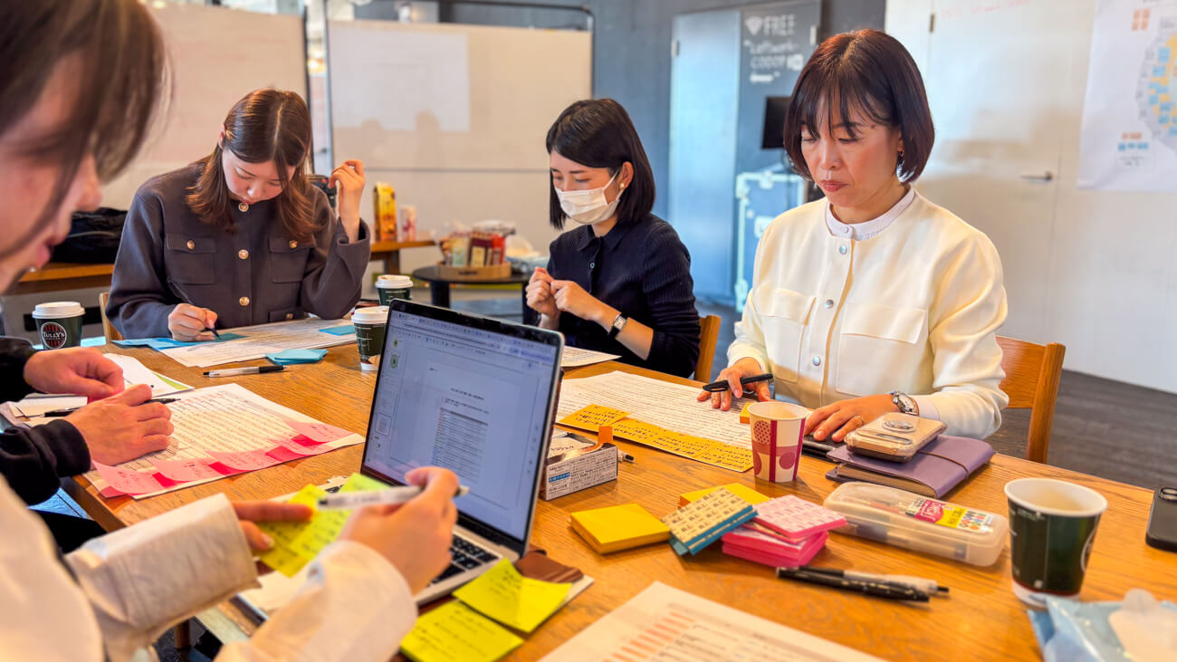 ロフトワークとセブン銀行のプロジェクトメンバーが机に向かい、子どもたちにとって重要な体験が何かを書き出している様子