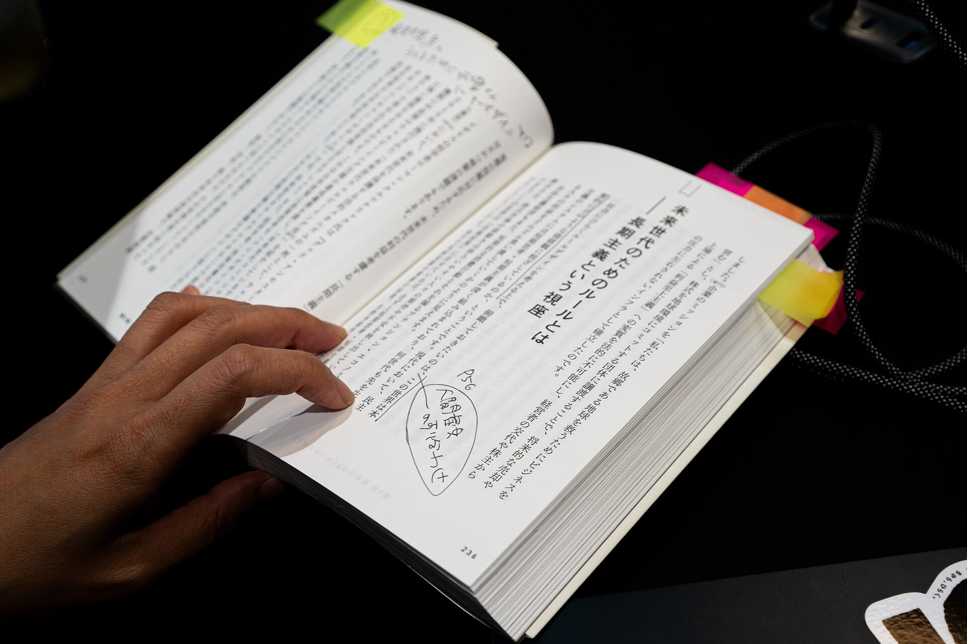 岩沢が書籍を開いて、気になったページにメモ書きをしている