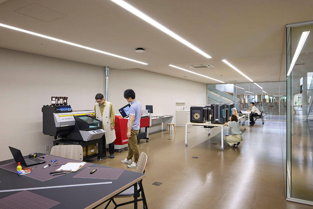 A Fab space filled with equipment like laser cutters and 3D printers. Users operate the machines and carry out their work.