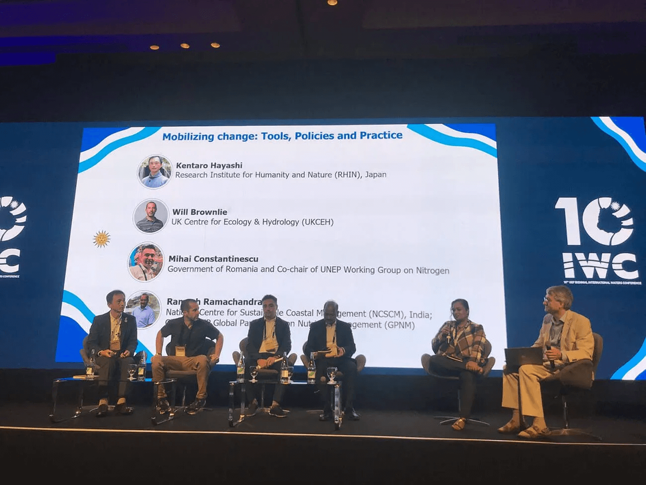 写真：国際会議の登壇の場で4名の男性研究者がパネルディスカッションを行なっている。左端に林さんが写っている。