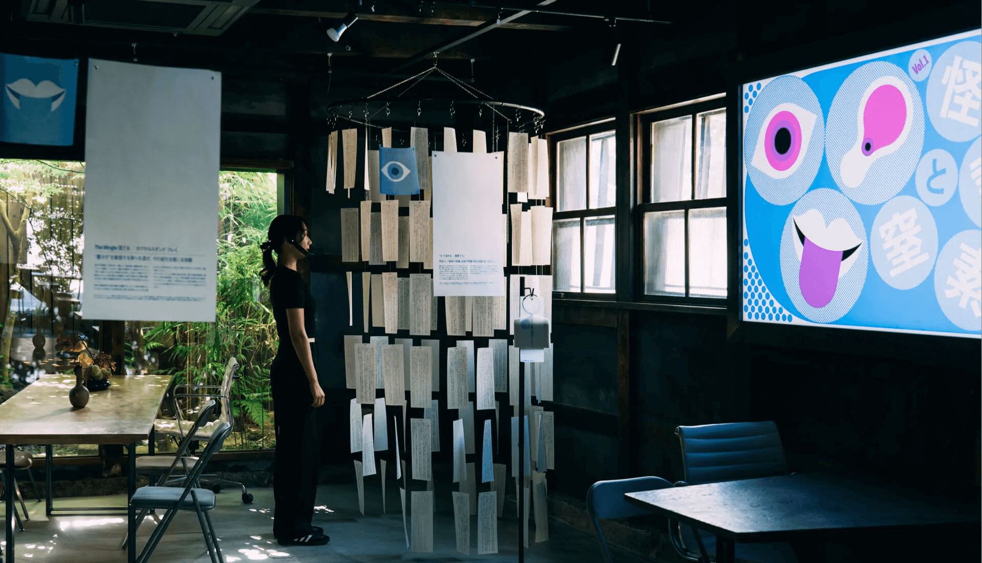 画像：展示「怪談と窒素」の会場を捉えた写真。モニターに展示のメインビジュアルが表示され、各展示物が会場内に展示されている全体像が撮られている。