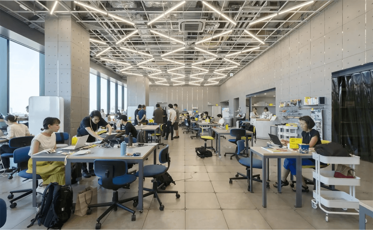 SHIBUYA QWSの共創スペース。広いフロアで多様な人々が作業や対話を行い、交流の拠点として活用されている